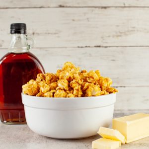 Caramel popcorn, syrup, and butter on table