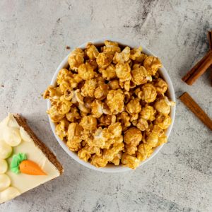 Caramel popcorn and carrot cake slice with cinnamon sticks.