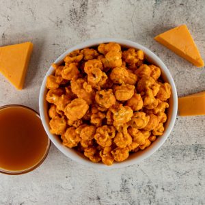 Cheddar popcorn in a bowl with cheese slices.